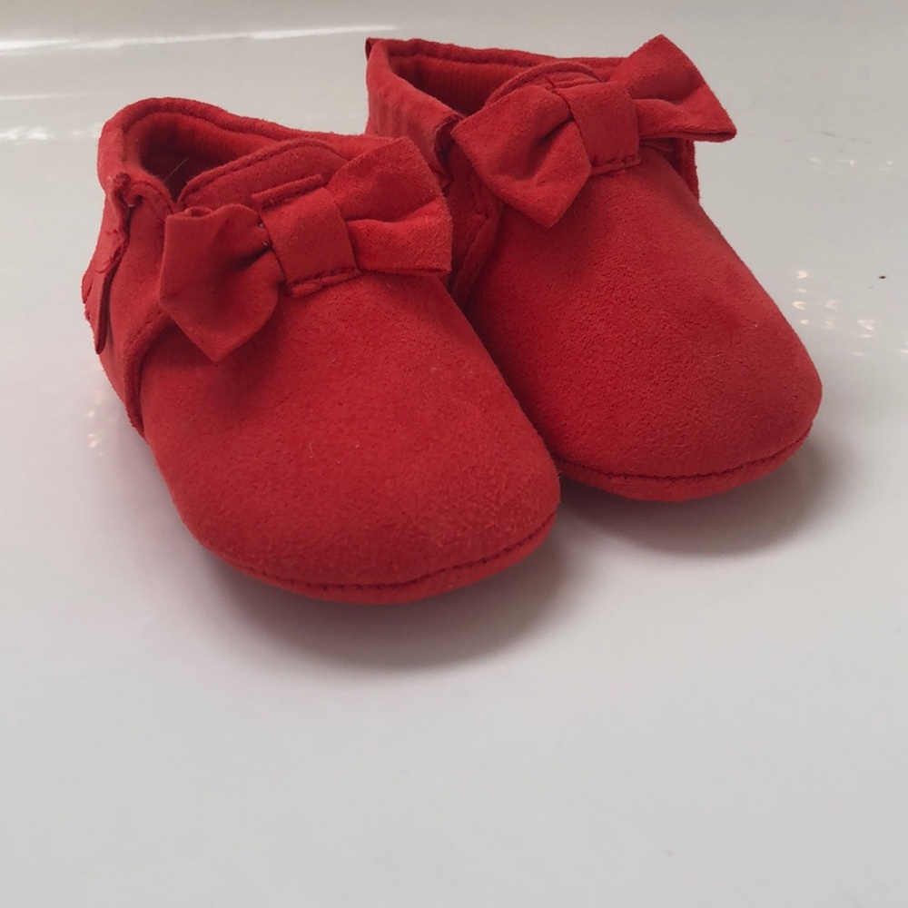 Red moccasins with fringe detail and bows